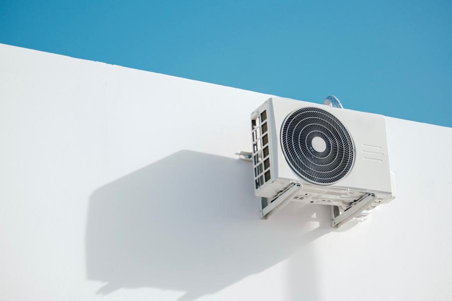 Unité extérieure de climatisation sur un mur blanc